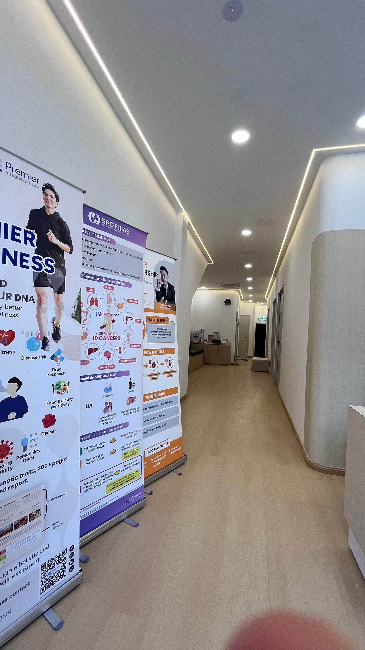 Clinic hallway with health screening programme displays at OneHealth Clinic Pontian